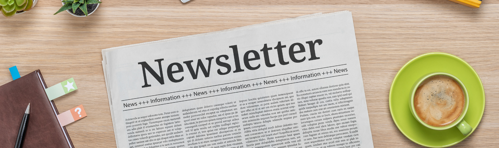 newsletter on a desk with green coffee cup